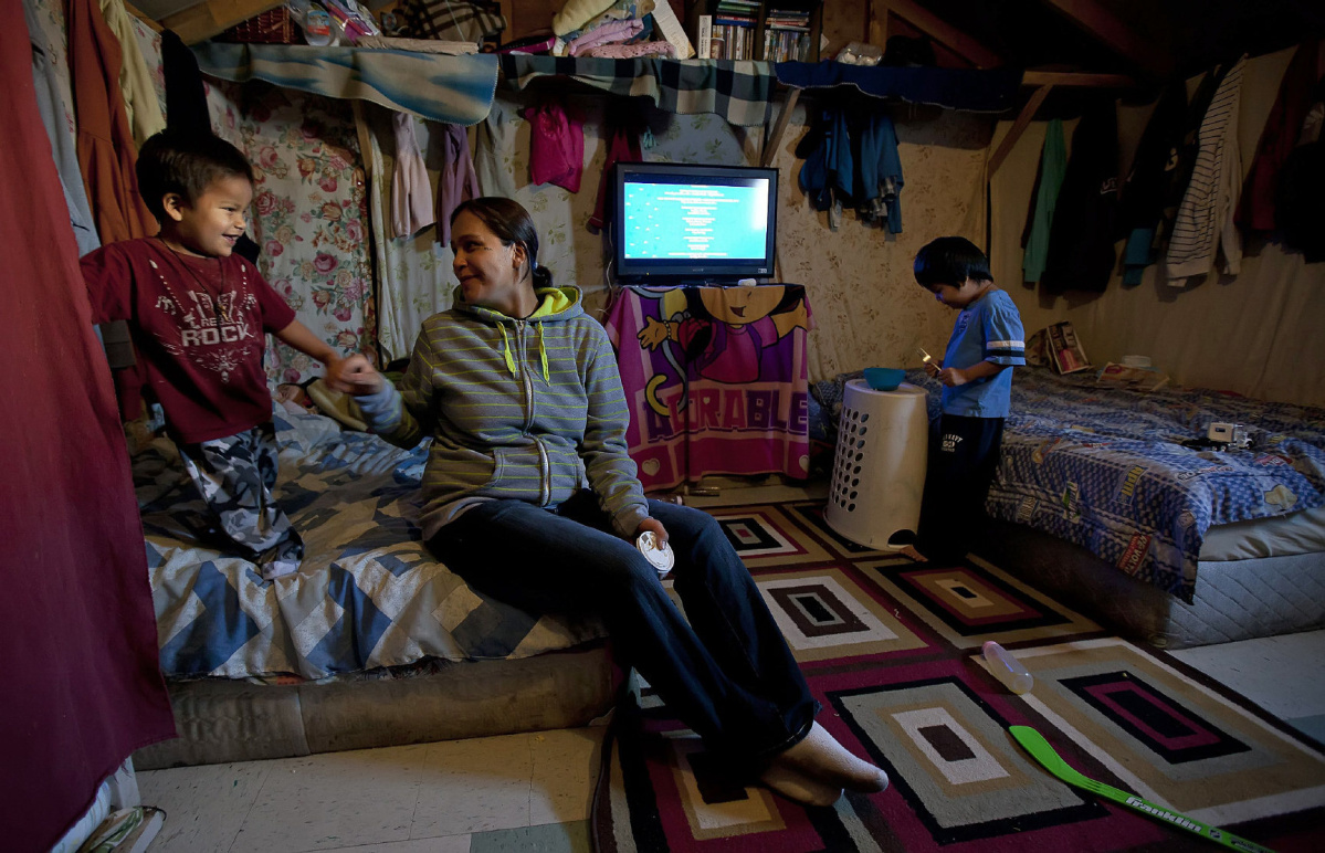 EDS: CORRECTS SPELLING OF ATTAWAPISKAT. Lisa Linklater plays with her son Keilyn and Drisdyn in a temporary shelter in Attawapiskat, Ont., Tuesday November 29, 2011.  Linklater has lived in the one room tent for approximately two years. THE CANADIAN PRESS/Adrian Wyld