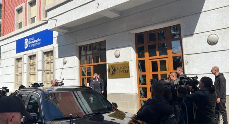 I shoqëruar nga Yuri Kim, Escobar vijon takimet në Tiranë. I shkon Alibeajt e Metës në zyrë